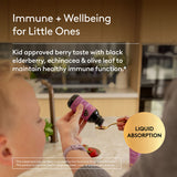 Person feeding a child a spoonful of a supplement with text about immune support for kids.